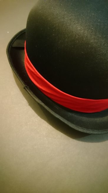 Red band of fabric slipped over derby hat