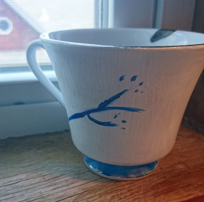 Teacup with painted blue floral design and base